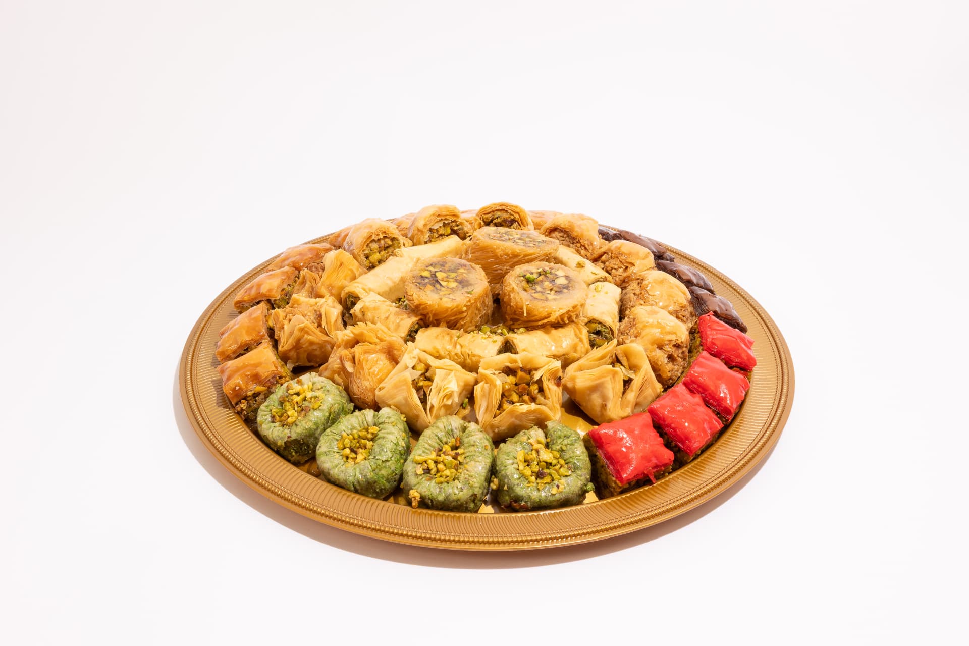 Gold platter of assorted Lebanese baklava and pistachio sweets